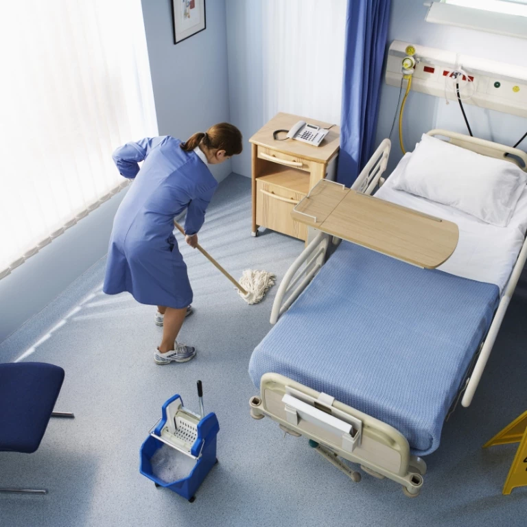 Kobieta sprzątająca pokój szpitalny